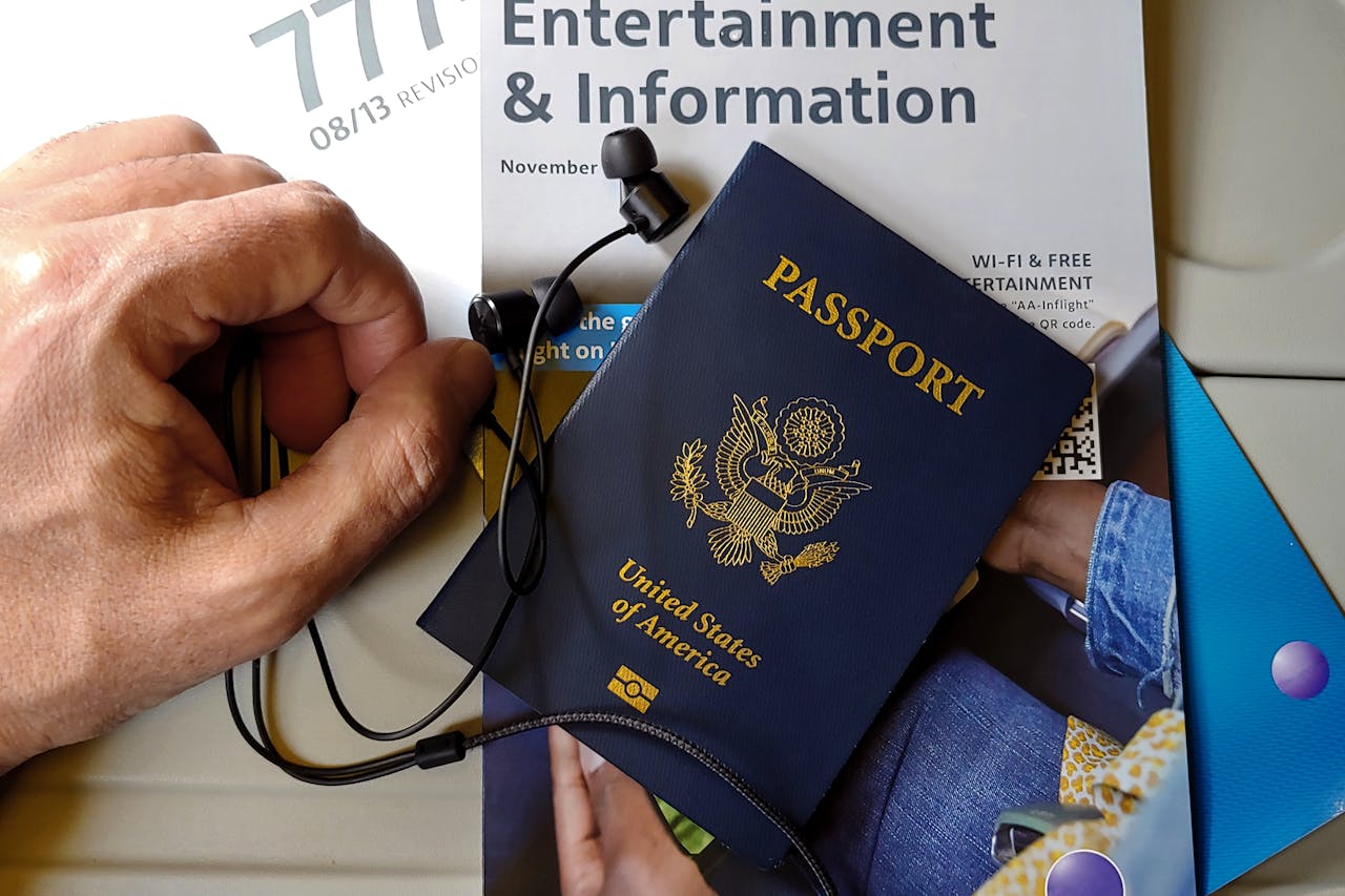 about-img Close-up of US passport with inflight magazine and headphones on an airplane seat, ready for travel.