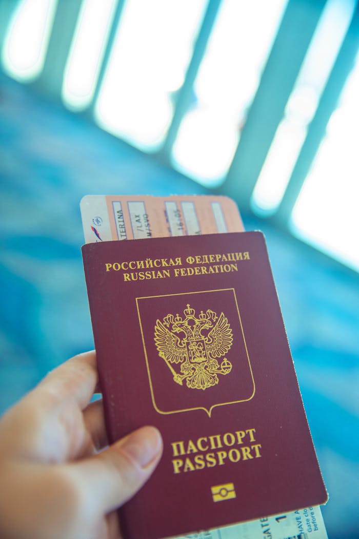 services-03 Russian passport held in hand with boarding pass peeking out, ready for travel.