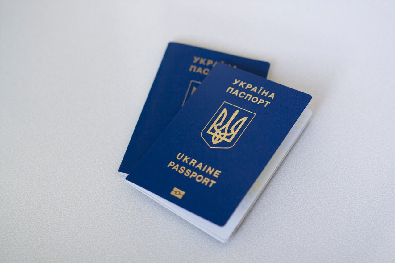 about-02 Blue Ukrainian passports on a light surface, highlighting travel documents.